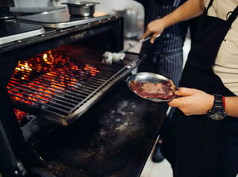 Koch grillt ein Steak.